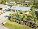 Aerial view of a well-maintained yellow house with metal roof and mature landscaping at 9031 Hilolo Ln, Venice, FL 34293