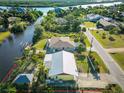 Aerial view of the property with canal access, featuring mature landscaping and a defined boundary at 9031 Hilolo Ln, Venice, FL 34293
