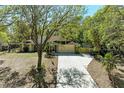 Exterior view of a home with a spacious driveway and attached garage, surrounded by mature trees at 1122 133Rd E St, Bradenton, FL 34212