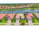 An aerial view of a residential home showcasing its location on the lake and red tile roof at 1290 Cielo Ct, North Venice, FL 34275