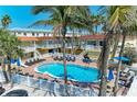 Lovely community pool surrounded by palm trees with lounge chairs for residents to relax and enjoy at 1325 Gulf Dr N # 247, Bradenton Beach, FL 34217