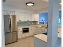 Kitchen featuring stainless steel appliances, white cabinetry, a stylish backsplash and quartz countertops at 210 73Rd Nw St, Bradenton, FL 34209