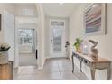 Inviting entryway with neutral tile flooring, complemented by a decorative table and artwork at 2756 Canoe Ln, North Port, FL 34286