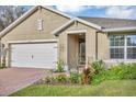 Charming single-story home featuring a manicured lawn, brick driveway, and attached two-car garage at 2756 Canoe Ln, North Port, FL 34286