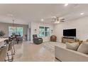 Open living space with neutral tile flooring, ceiling fan, and comfortable seating at 2756 Canoe Ln, North Port, FL 34286
