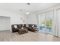 Bright living room boasts wood laminate floors and sliding glass doors opening to the pool at 3319 Mayflower St, Sarasota, FL 34231
