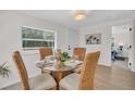 Bright dining area with modern light fixture, round glass table, and stylish woven chairs at 3561 Elfers Pkwy, New Port Richey, FL 34655