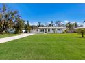 Charming single story home featuring a lush, green lawn and a long driveway at 426 S Shore Dr, Sarasota, FL 34234