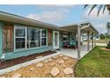 Inviting front porch with a seating area, complemented by charming landscaping and stylish shutters at 4524 106Th W St, Bradenton, FL 34210