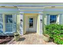 Inviting front entrance with brick walkway, decorative plants, and charming light-yellow walls at 5 Barbados Rd # 31, Englewood, FL 34223