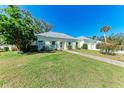 Well-maintained home with lush green lawn, mature trees, and a light-yellow exterior at 5 Barbados Rd # 31, Englewood, FL 34223