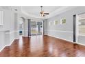 Bright living room with hardwood floors, transom windows, and sliding glass doors leading to the outdoor space at 5234 Aqua Breeze Dr, Bradenton, FL 34208