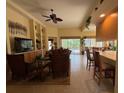 Open living room with built-in shelving and large windows overlooking the pool at 5962 Roseto Pl, Sarasota, FL 34238