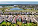 Beautifully landscaped home highlighted in aerial shot of vibrant neighborhood near tranquil lake at 6136 Voyagers Pl, Apollo Beach, FL 33572