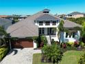 Beautiful home with a well manicured lawn, brick driveway, tropical plants and two-car garage at 6208 Signature Pointe Ln, Bradenton, FL 34210