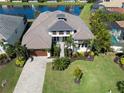 Beautiful home with tropical plants, well manicured lawn and a fountain in the lake behind the house at 6208 Signature Pointe Ln, Bradenton, FL 34210