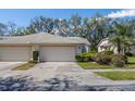 Home featuring an attached garage and meticulously landscaped front yard showcasing vibrant flowers at 6345 Stone River Rd # 6345, Bradenton, FL 34203