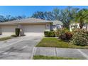 Home featuring an attached garage and meticulously landscaped front yard showcasing vibrant flowers at 6345 Stone River Rd # 6345, Bradenton, FL 34203