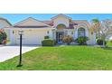 Charming front exterior features a well-maintained lawn, beautiful landscaping, and a two-car garage at 6514 Stone River Rd, Bradenton, FL 34203