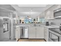 Bright kitchen featuring white cabinetry, stainless steel appliances, and a convenient breakfast bar at 6707 Stone River Rd # 105, Bradenton, FL 34203
