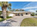 Inviting home with a long driveway, lush grass, and mature trees at 7211 Antigua Pl, Sarasota, FL 34231