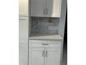 Close up of the kitchen cabinets with a stone backsplash and stone countertop at 728 41St St St, Sarasota, FL 34234