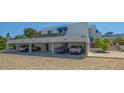 Modern, multi-level home featuring covered parking, lush landscaping and stairs to upper level entrance at 740 Bayport Way # 740, Longboat Key, FL 34228