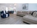 Bright living room with wood-look floors, comfortable seating, and an open layout leading to the kitchen at 800 Everest Rd, Venice, FL 34293