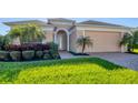 Charming single-Gathering home boasts an arched entrance, lush landscaping, and a well-maintained front yard at 1014 Calico Gln, Bradenton, FL 34212