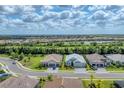 Beautiful aerial view of residential neighborhood, showcasing well-manicured lawns, lake, and mature trees at 13306 Deep Blue Pl, Bradenton, FL 34211