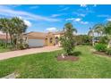 Beautiful single-story home with a well-manicured lawn and mature palm trees at 13320 Coluccio St, Venice, FL 34293