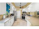 Bright kitchen features white cabinets, stainless appliances, and tile flooring at 13320 Coluccio St, Venice, FL 34293