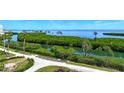 Scenic view of the landscaping with lush green trees and plants with a beautiful body of water in the background at 1930 Harbourside Dr # 136, Longboat Key, FL 34228