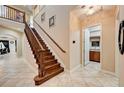 Bright foyer with hardwood staircase, tiled floors, and a convenient half-bathroom adjacent to the entry area at 2512 61St E Ave, Ellenton, FL 34222