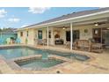 Beautiful backyard pool and spa with brick surround, covered patio, and serene water views at 3419 31St E St, Bradenton, FL 34208