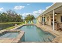 Relaxing backyard pool and spa overlooking a tranquil pond, with a covered patio and outdoor seating at 3419 31St E St, Bradenton, FL 34208