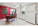 Bright kitchen and dining area featuring white cabinets, appliances, and a table with seating at 3461 Tallywood Cir # 7067, Sarasota, FL 34237