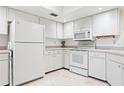 Efficient kitchen featuring all-white appliances and cabinets, offering a clean and classic look at 3461 Tallywood Cir # 7067, Sarasota, FL 34237