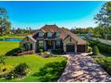 A stunning aerial view of the home featuring impeccable landscaping, a brick-paved driveway and a serene pond at 3712 59Th Avenue E Cir, Ellenton, FL 34222