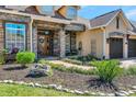 Inviting home entrance with stone accents, a brick walkway, lush landscaping, and a cozy seating area at 3712 59Th Avenue E Cir, Ellenton, FL 34222