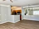Open living room with wood floors leading into the kitchen with modern lighting and a large decorative mirror at 4802 51St W St # 1420, Bradenton, FL 34210