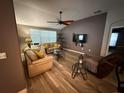 Spacious living room with modern ceiling fan, neutral tones, and stylish wood laminate flooring at 509 Stone Briar Dr, Ruskin, FL 33570