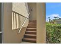 Carpeted condo stairway with a white railing and a wall-mounted fire extinguisher at 5211 Mahogany Run Ave # 126, Sarasota, FL 34241