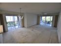 Bright living room featuring sliding glass doors to the patio and a decorative chandelier at 5684 Sheffield Greene Cir # 79, Sarasota, FL 34235