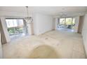 Spacious living room with patio access and a stylish chandelier, offering an indoor-outdoor flow at 5684 Sheffield Greene Cir # 79, Sarasota, FL 34235
