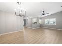 Bright living room features wood-look flooring, modern light fixture, and large windows at 5814 Garden Lakes Fern, Bradenton, FL 34203