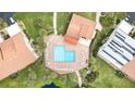 Aerial view of a community pool with lounge chairs and tables surrounded by landscaping at 756 Avenida Estancia # 162, Venice, FL 34292