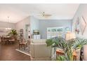 Bright and airy living room with wood flooring, a ceiling fan, and sliding glass doors opening to the pool area at 7767 Pine Trace Dr, Sarasota, FL 34243