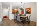 Elegant dining room featuring a chandelier, artwork and tile floors, open to the kitchen at 7959 Limestone Ln # 14-104, Sarasota, FL 34233