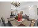 Cozy living room and dining area with a chandelier, ceiling fan and open floor plan at 7959 Limestone Ln # 14-104, Sarasota, FL 34233